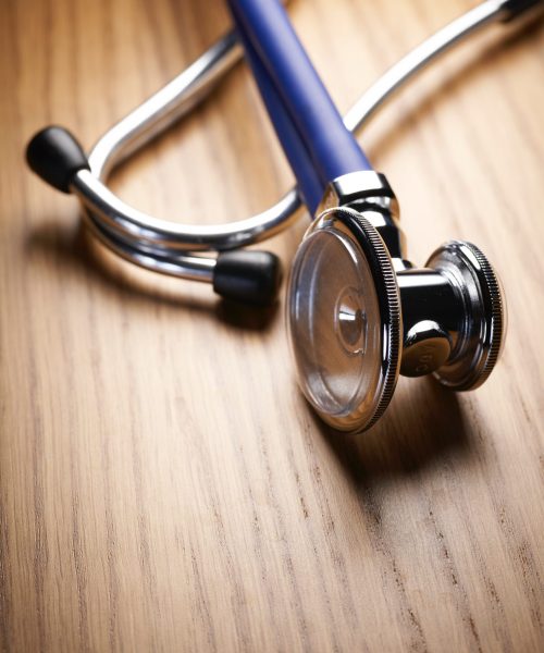 A stethoscope lying on a wooden table